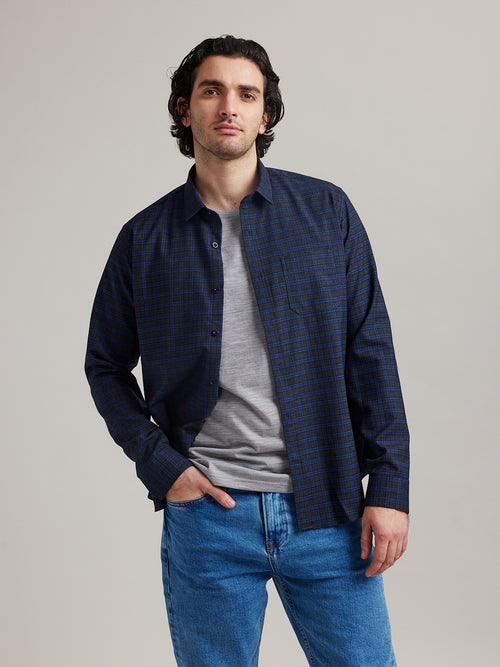 Man wears a merino wool flannel shirt in green navy check pattern with chestpocket