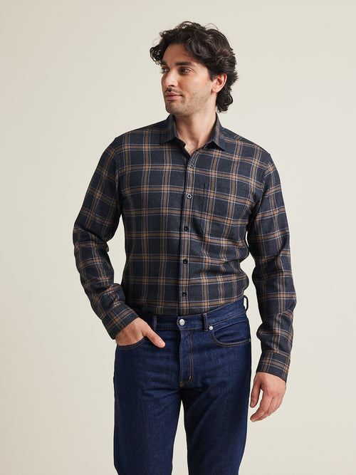 L’homme porte une chemise en flanelle de laine mérinos de Wolk à motif à carreaux gris marron avec poche poitrine