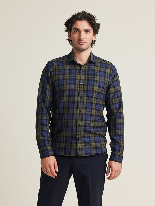 Homme porte une chemise en laine mérinos en flanelle à motif bleu vert à carreaux sur un pantalon bleu
