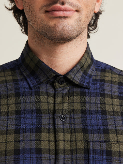 Close-up de chemise en flanelle de laine mérinos à carreaux bleu-vert avec boutons en corozo bleu de Wolk 
