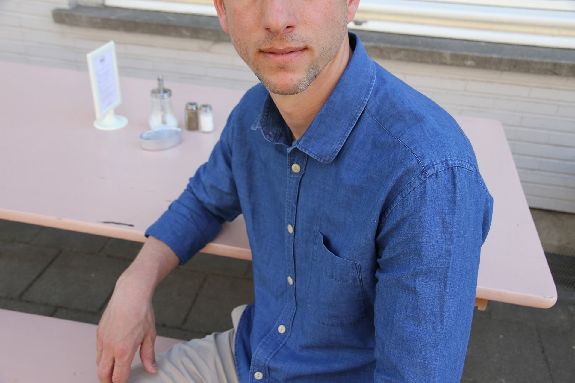 man sitting on terras in linen shirt with chest pocket made by Wolk