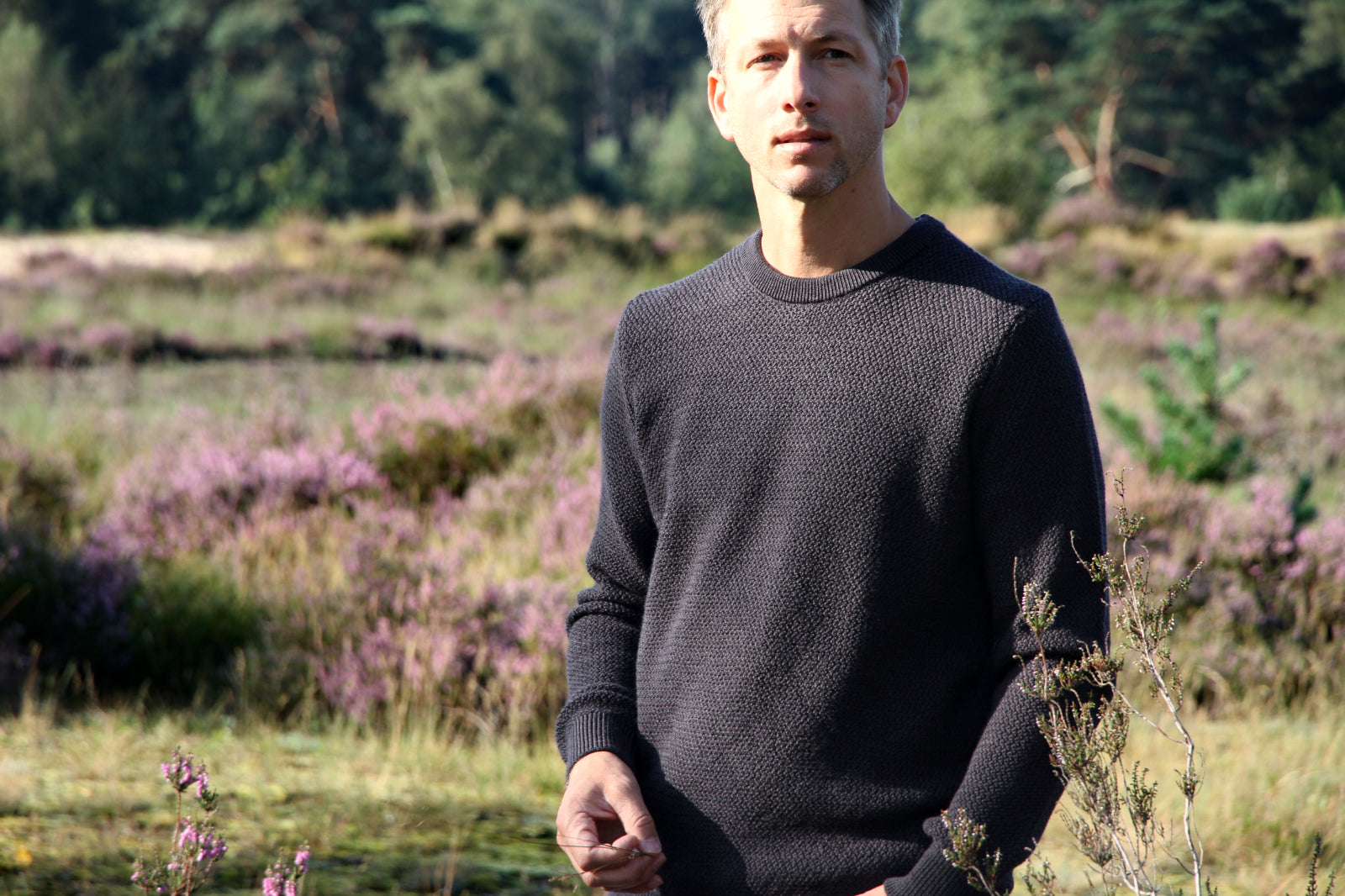 Man wearing merino wool sweater in dark grey color in rice knit pattern