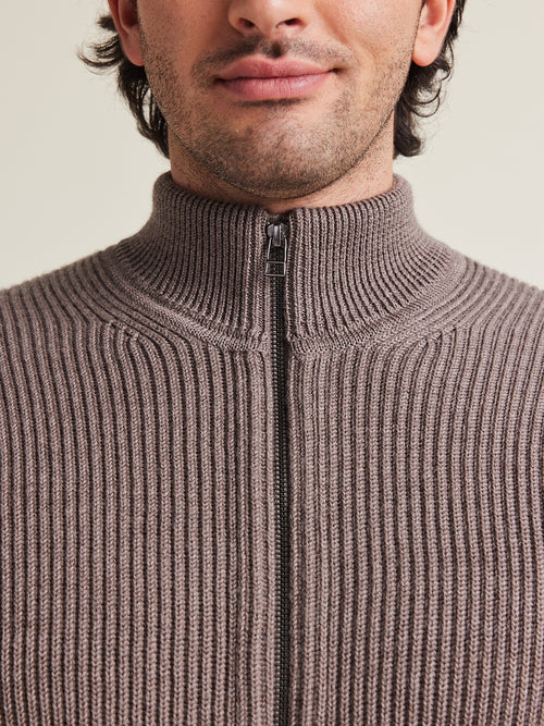Close up of high collar zipped sweater in brown color and cardigan knit structure from Wolk
